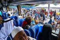  Dari balik jendela bus, jemaah haji Kloter 24 melambaikan tangan ke arah ratusan keluarga dan warga yang telah memadati Alun-alun Kota Kuala Tungkal, Senin (29/06). (FOTO : Dok. Prokopim)