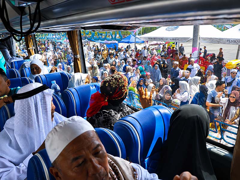  Dari balik jendela bus, jemaah haji Kloter 24 melambaikan tangan ke arah ratusan keluarga dan warga yang telah memadati Alun-alun Kota Kuala Tungkal, Senin (29/06). (FOTO : Dok. Prokopim)
