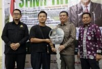 Wakil Bupati Tanjab Barat Dr. H. Katamso dampingi Anggota Komisi XII DPR RI Elpisina menyerahkan bantuan motor roda tiga pengangkut sampah dari Kementerian Lingkungan Hidup kepada kelompok masyarakat pada acara Bimtek Pengurangan Sampah di Kuala Tungkal (10/9/2026). (FOTO : Dok. Prokopim)