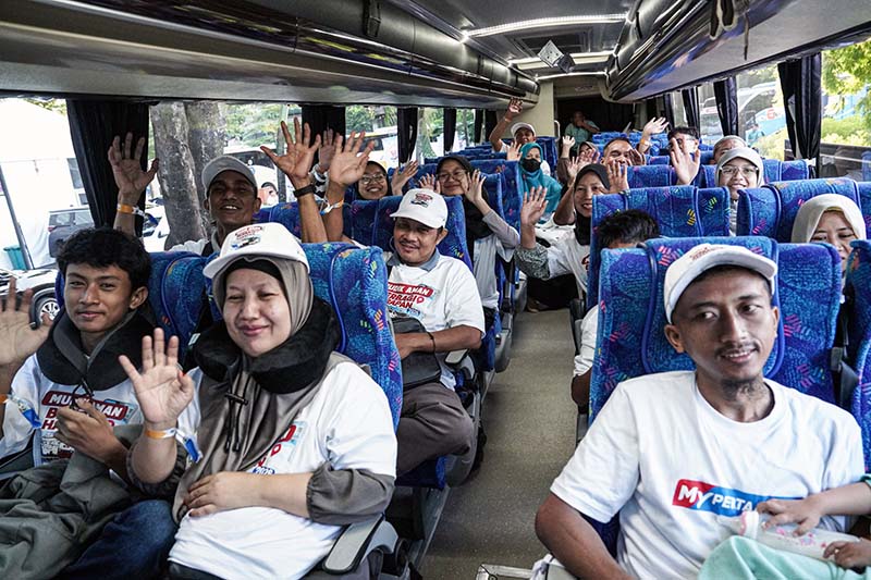 Para peserta program Mudik Gratis Bareng MyPertamina melambaikan tangan sesaat sebelum bus diberangkatkan menuju kampung halaman, Sabtu (15/3). Inisiatif ini merupakan bentuk apresiasi Pertamina Patra Niaga kepada para mitra pengemudi ojol yang menjadi bagian penting dalam ekosistem layanan MyPertamina. (FOTO : LINTASTUNGKAL)