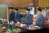 Bupati Drs. H. Anwar Sadat, M.Ag., bersama Wakil Bupati Dr. H. Katamso, SA, S.E., M.E., dan jajaran pimpinan DPRD Tanjab Barat saat berdiri menyanyikan lagu Indonesia Raya dalam Rapat Paripurna mendengarkan Pidato Kenegaraan Presiden RI di Gedung DPRD Tanjab Barat, Jumat (14/08/2026). (FOTO : Dok. Prokopim)
