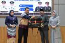 Bupati Tanjab Barat H. Anwar Sadat menyerahkan plakat penghargaan dan cindera mata kepada AKBP Maulia Kuswicaksono sebagai bentuk apresiasi atas dedikasinya selama menjabat sebagai Kapolres Tanjung Jabung Barat, Jumat (11/09/2026). (FOTO : Dok. PROKOPIM)