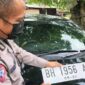 KBO Satlantas Polres Muaro Jambi IPTU Made Yoso Menunjuk Plat Berwarna Dasar Putih. FOTO : Humas PMJ