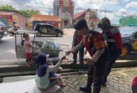 Personil Ditsamapta Polda Jambi Bagikan Makanan ke Warga Kurang Mampu di Jalan. FOTO : Dhea/LT