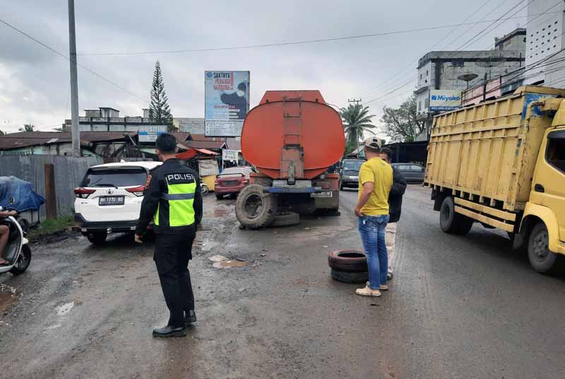 Polisi Lalulintas Direktorat Lalu Lintas Polda Jambi Tengah Mengurai  kemacetan panjang di Desa Jebak,  Kabupaten Batanghari, Sabtu (10/9/22). FOTO : Humas 