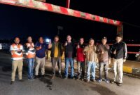 Pelaksana Tugas (Plt.) Kepala Dinas Perhubungan Kota Sungai Penuh, Dianda Putra, S.STP., M.Si (kelima dari kiri), bersama jajaran petugas Dishub dan personel lapangan berfoto bersama di depan Portal Jembatan Kerinduan yang baru selesai diperbaiki. (FOTO : Dok. Istimewa/Dianda Putra)