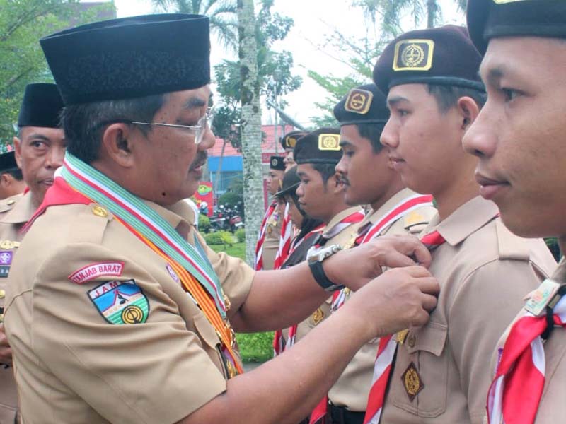 Bupati Tanjab Barat, H. Anwar Sadat sekaligus Kamabicab Gerakan Pramuka Tanjab Barat Menyematkan Penghargaan Kepada Peserta pada upacara Apel Peringatan  Pramuka ke-63 tingkat Kwartir Cabang (Kwarcab) Gerakan Pramuka Tanjung Jabung Barat Tahun 2024. Rabu (21/8/24). FOTO : PANITIA