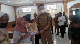 Pj Bupati Muaro Jambi Bachyuni Deliansyah Menyerahkan Bantuan BTPKLW Migor Secara Simbolis Keada Salah Satu Penerima, Senin (30/5/22). FOTO : Noval