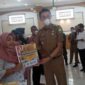 Pj Bupati Muaro Jambi Bachyuni Deliansyah Menyerahkan Bantuan BTPKLW Migor Secara Simbolis Keada Salah Satu Penerima, Senin (30/5/22). FOTO : Noval