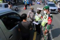 Petugas gabungan memeriksa dokumen pengendara di check point penyekatan arus mudik di kawasan Pasar Mudik, Bogor, (7/5/2021). Penyekatan pemudik pada jalur alternatif Parung diberlakukan jelang Lebaran guna mengantisipasi risiko peningkatan kasus COVID-19. (merdeka.com/Arie Basuki)