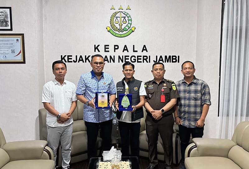 Ketua PWI Kota Jambi Irwansyah dan Kepala Kejaksaan Negeri Jambi M.N Ingratubun, SH, MH saling Memberikan Cinderamatan, Selasa (11/6/24). FOTO : Hms