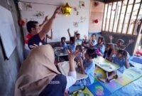 Relawan Pertamina Patra Niaga Regional Sulawesi bersama kelompok masyarakat binaan mengajak anak-anak berinteraksi dalam sesi pembelajaran berbasis pengalaman (experiential learning) di Rumah Anak Pesisir (RASI), Pemukiman Candi, Kota Bitung, Sulawesi Utara. (Foto: Dok. Pertamina Patra Niaga)