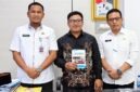 Sekda, Hermansyah berfoto bersama finalis IRIFair 2026, M. Arif Rahman Hakim (tengah) yang memegang modul riset "Arakan Sahur", dan Kepala Bapperida Tanjab Barat, Dr. H. Feri Elvianto, (kanan), usai audiensi dukungan riset robotika tingkat nasional di ruang kerja Sekda, Rabu (16/09). (Dok. Prokopim Tanjab Barat)