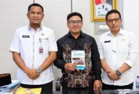 Sekda, Hermansyah berfoto bersama finalis IRIFair 2026, M. Arif Rahman Hakim (tengah) yang memegang modul riset "Arakan Sahur", dan Kepala Bapperida Tanjab Barat, Dr. H. Feri Elvianto, (kanan), usai audiensi dukungan riset robotika tingkat nasional di ruang kerja Sekda, Rabu (16/09). (Dok. Prokopim Tanjab Barat)