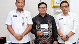 Sekda, Hermansyah berfoto bersama finalis IRIFair 2026, M. Arif Rahman Hakim (tengah) yang memegang modul riset "Arakan Sahur", dan Kepala Bapperida Tanjab Barat, Dr. H. Feri Elvianto, (kanan), usai audiensi dukungan riset robotika tingkat nasional di ruang kerja Sekda, Rabu (16/09). (Dok. Prokopim Tanjab Barat)