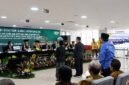 Bupati H. Anwar Sadat, (berdiri mengenakan kemeja batik biru dan peci hitam), menghadiri Sidang Terbuka Promosi Doktor Estiarty Haryani, S.Pt., M.T., di Kampus Universitas Indonesia, Salemba, Jakarta Pusat, Sabtu (4/7). Dalam sidang tersebut, Estiarty mempertahankan disertasinya yang meneliti strategi produktivitas hijau (green productivity) industri kelapa sawit dengan lokus penelitian di Kabupaten Tanjung Jabung Barat, Jambi. (Foto: Dok. Prokopim Tanjabbar)