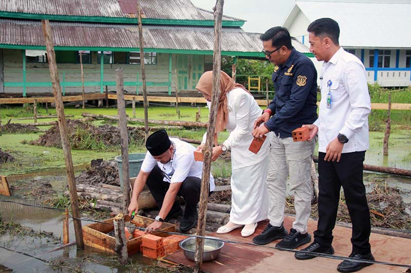 Sekda, Hermansyah, S.STP., M.H. (jongkok), meletakkan batu pertama pembangunan mushola di SMKN 1 Tanjung Jabung Barat, Rabu (3/6). Kegiatan ini turut disaksikan oleh Kepala SMKN 1 Tanjab Barat Heni Septi Nuraini, S.Pd., M.Pd.I., serta jajaran terkait sebagai simbol dimulainya pembangunan fasilitas penguat karakter spiritual siswa. (Foto: Dok. Humas/Istimewa)