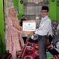 Pauzan Najri menyerahkan bantuan kepada Orang Tua Siswi SMPN 2 Kuala Tungkal yang mengalami musibah kebakaran. FOTO : Dok. SMPN 2 Kuala Tungkal