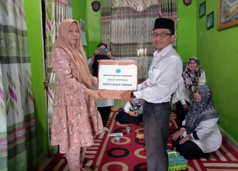 Pauzan Najri menyerahkan bantuan kepada Orang Tua Siswi SMPN 2 Kuala Tungkal yang mengalami musibah kebakaran. FOTO : Dok. SMPN 2 Kuala Tungkal