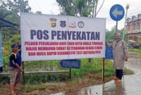 Pstugas Ketika Memasang Spanduk Sosialisasi Penyekatan di Pos Penyeatan Terminal Pembengisn. FOTO : ISTIMEWA