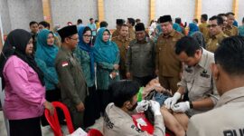 Sinergi kemanusiaan Pemkab, Baznas, dan TP-PKK Kabupaten Tanjung Jabung Barat dalam menghadirkan layanan khitanan massal gratis bagi warga. Tampak Wakil Bupati H. Katamso bersama para pejabat daerah memberikan dukungan moral kepada anak yang sedang dikhitan oleh tim medis, Selasa (23/6). (Foto: Dok. Prokopim Tjb)