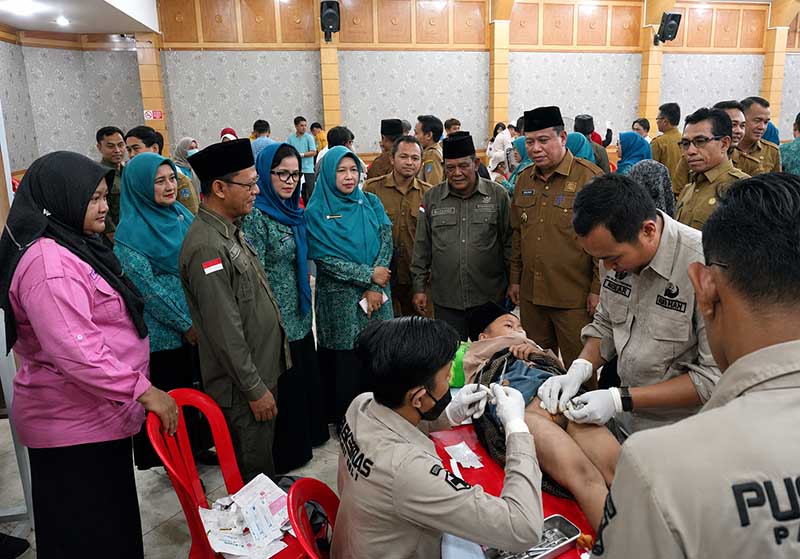 Sinergi kemanusiaan Pemkab, Baznas, dan TP-PKK Kabupaten Tanjung Jabung Barat dalam menghadirkan layanan khitanan massal gratis bagi warga. Tampak Wakil Bupati H. Katamso bersama para pejabat daerah memberikan dukungan moral kepada anak yang sedang dikhitan oleh tim medis, Selasa (23/6). (Foto: Dok. Prokopim Tjb)