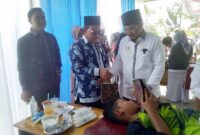 Bupati Tanjung Jabung Barat H Anwar Sadat didampingi Kepala Dinas Kesehatan H Zaharuddin bagikan bingkisan kepada Anak yang di Khitan, Rabu (2/8/23). FOTO : LT