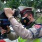 Anggota Satuan Lalu Lintas Polres Muaro Jambi Menggunakan Speed Gan Mengukur Kecepatan dan Kelambatan Kendaraan di Jalan Raya, Kamis (10/3/22). FOTO : HUMAS PMJ