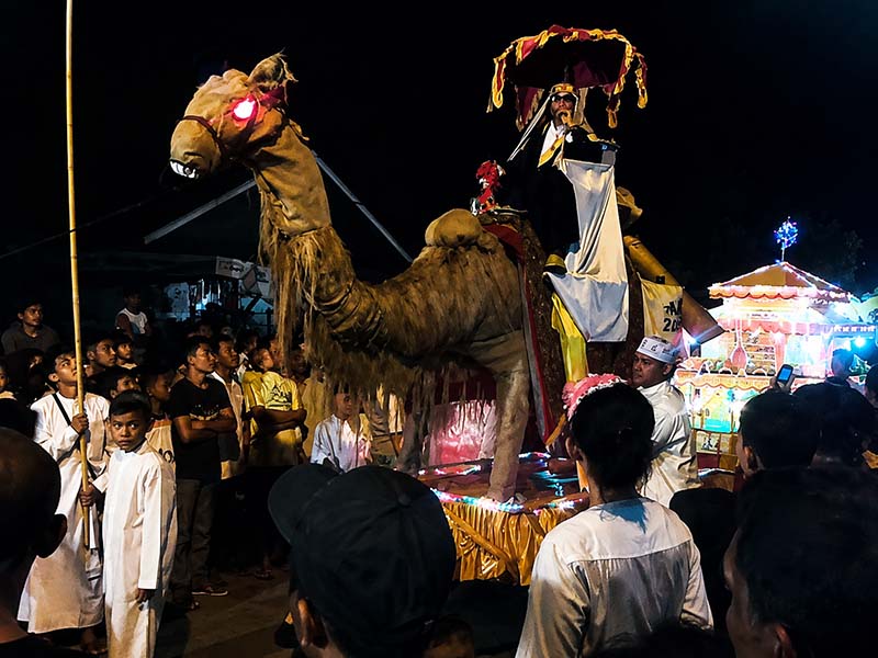 KREATIF DAN MERIAH: Salah satu kafilah peserta Festival Pawai Takbiran Idul Adha menampilkan replika unta raksasa lengkap dengan dekorasi khas Timur Tengah saat melintasi jalur utama di Kuala Tungkal pada tahun 2022. Acara ini sukses menyedot perhatian ribuan warga yang memadati sepanjang rute pawai. (FOTO : Dok. Isitimewa/LINTASTUNGKAL)