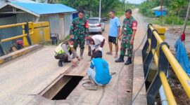 Bhabinkamtibmas, Babinsa, Masyarakat dan Dinas Perhubungan Tanjung Jabung Barat saling bantu memperbaiki Jembatan di Sungai Landak. FOTO : Polsek Pengabuan