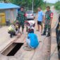 Bhabinkamtibmas, Babinsa, Masyarakat dan Dinas Perhubungan Tanjung Jabung Barat saling bantu memperbaiki Jembatan di Sungai Landak. FOTO : Polsek Pengabuan