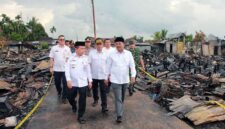 Gubernur Jambi Al Haris didampingi Bupati Tanjab Barat Anwar Sadat dan rombongan berjalan di antara puing-puing sisa kebakaran saat meninjau langsung lokasi terdampak di Kelurahan Teluk Nilau, Rabu (6/5/2026). Kunjungan ini bertujuan untuk menyerahkan bantuan sekaligus memastikan percepatan pemulihan bagi 70 kepala keluarga yang kehilangan tempat tinggal. (FOTO : Dok. PROKOPIM)
