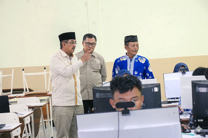 Bupati Tanjung Jabung Barat, Drs. H. Anwar Sadat, M.Ag., saat meninjau langsung pelaksanaan Tes Kemampuan Akademik (TKA) 2026 berbasis komputer di salah satu SMP negeri, Kamis (09/04). Meski ditujukan untuk memetakan mutu siswa, Pemkab mengakui keterbatasan fasilitas laboratorium komputer masih menjadi hambatan utama pemerataan standar pendidikan di wilayah tersebut. (FOTO : Dok. Prokopim)
