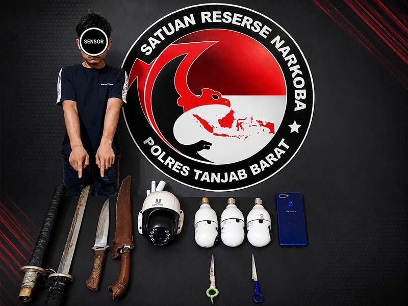 Terduga pelaku berinisial M.N.S (23) saat diamankan di Mapolres Tanjung Jabung Barat bersama sejumlah barang bukti yang berhasil disita dalam penggerebekan di Desa Pematang Lumut, Kecamatan Betara. (Foto: Dok. Humas Polres Tanjab Barat)
