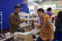 Salah satu pelaku UMKM mitra binaan PT Pertamina (Persero) tengah menjelaskan keunggulan produk alas kaki lokal kepada pengunjung dalam pameran dagang internasional. (Foto: Dok. Pertamina)