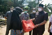Wakil Bupati Hairan, SH Menyerahkan Bantuan Kepada Ibu Husnah keluarga tertimpa musibah kebakaran di RT.07 Dusun Rantau Panjang Desa Kelagian Kecamatan Tebing Tinggi, Rabu (28/07/21). FOTO : PROKOPIM