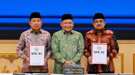 Bupati H. Anwar Sadat (kanan) bersama Ketua DPRD Tanjab Barat Hamdani (kiri) menunjukkan Laporan Hasil Pemeriksaan (LHP) atas LKPD Tahun Anggaran 2025 didampingi Kepala BPK RI Perwakilan Provinsi Jambi (tengah) di Kantor BPK RI Perwakilan Jambi, Selasa (2/6/2026). (FOTO : Dok. Istimewa Prokopim TJB)