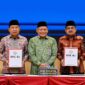 Bupati H. Anwar Sadat (kanan) bersama Ketua DPRD Tanjab Barat Hamdani (kiri) menunjukkan Laporan Hasil Pemeriksaan (LHP) atas LKPD Tahun Anggaran 2025 didampingi Kepala BPK RI Perwakilan Provinsi Jambi (tengah) di Kantor BPK RI Perwakilan Jambi, Selasa (2/6/2026). (FOTO : Dok. Istimewa Prokopim TJB)