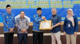 Bupati H. Anwar Sadat menerima penghargaan Opini WTP dari Kakanwil Ditjen perbendaharaan Jambi Supendi atas LKPD Tanjab Barat Tahun 2021, Kamis (17/11/22/. FOTO : Ist