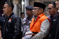 Keterangan Foto:
Mantan Menteri Agama, Yaqut Cholil Qoumas (YCQ), mengenakan rompi oranye tahanan KPK dengan pengawalan ketat petugas saat berada di Gedung Merah Putih KPK, Jakarta. Status penahanan YCQ kini telah dialihkan menjadi tahanan rumah terhitung sejak Kamis (19/3/2026) hingga 31 Maret 2026 mendatang. (FOTO : Samuderafakta.com)