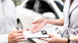 Automotive business, car sale or rental concept : Happy customer with car dealer agent making deal and signing on agreement document contract in auto showroom or car dealer office. FOTO : Ist/Net