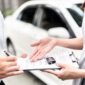 Automotive business, car sale or rental concept : Happy customer with car dealer agent making deal and signing on agreement document contract in auto showroom or car dealer office. FOTO : Ist/Net