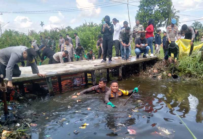 Kapolres AKBP Padli, SH, SIK, MH ditemani Bripda Iqbal terjun ke Sungai Parit 2 Kelurahan Patunas saat gotong royong, Selasa (15/8/23). FOTO : LT