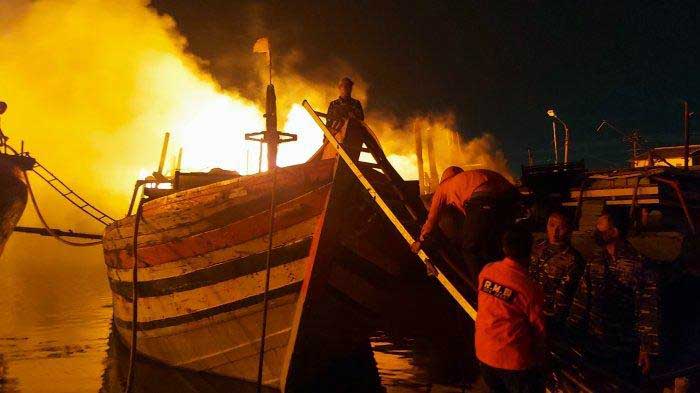 Petugas berusaha memadamkan api di Pelabuhan Perikanan Pantai (PPP) Tegalsari atau lebih dikenal Pelabuhan Jongor Tegal, Senin (14/8/23). FOTO : tribunbanyumas