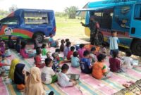 Dansatgas TMMD Ke-112 Kodim 1002/HST, Letkol Inf Muh. Ishak HB Tengah Bersama Anak-anak dengan Perpustakaan Keliling, Selasa, (12/10/21).