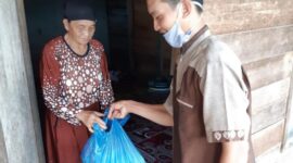 FOTO : HB Saat Baksos Membagikan Paket Sembako dari Polres Tanjab Barat di RT 016 Bina Karya Selatan, Jumat (29/05/20).